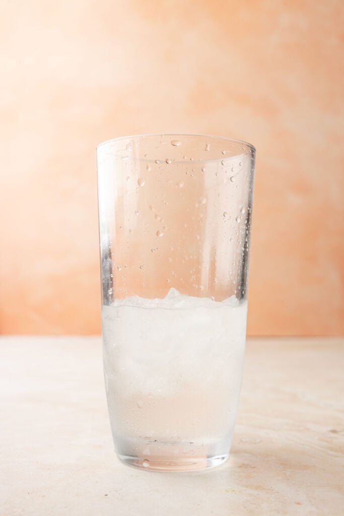 Ice and tequila in a cocktail shaker.
