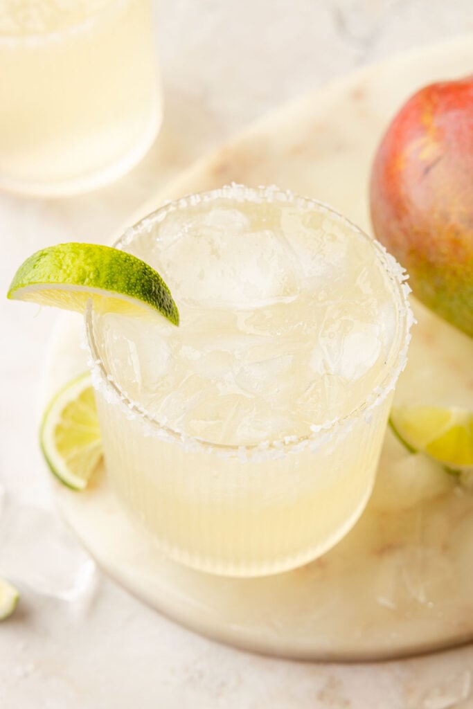 Mango Margarita with a lime on a piece of marble with mangos