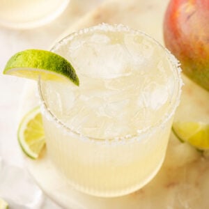 Mango Margarita with a lime on a piece of marble with mangos