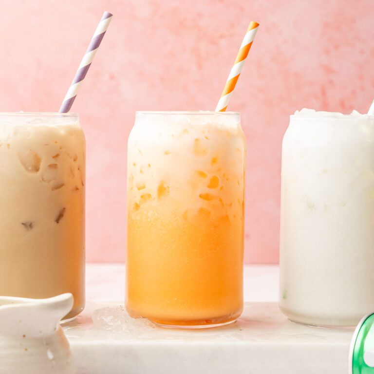 Dirty soda tray with Dirty root beer, dirty, orange soda, and dirty Sprite on a marble surface with fun striped straws