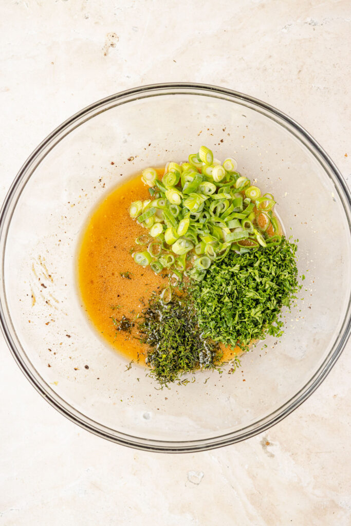 Herb vinaigrette being made in a mixing bowl.