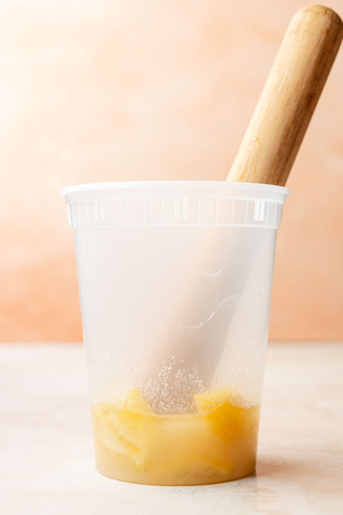 Container filled with sugar and lemons being smashed