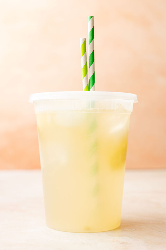 Finished Mango Lemonade in a container with a straw