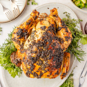 Herb Roasted Chicken on a plater with fresh herbs