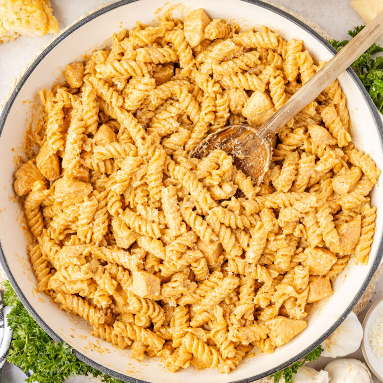 Creamy Chicken and Garlic Pasta in a pan wiht a wooden spoon