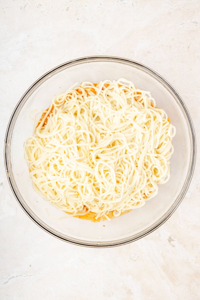 Sesame sauce and a large mixing bowl topped with lo mein noodles.