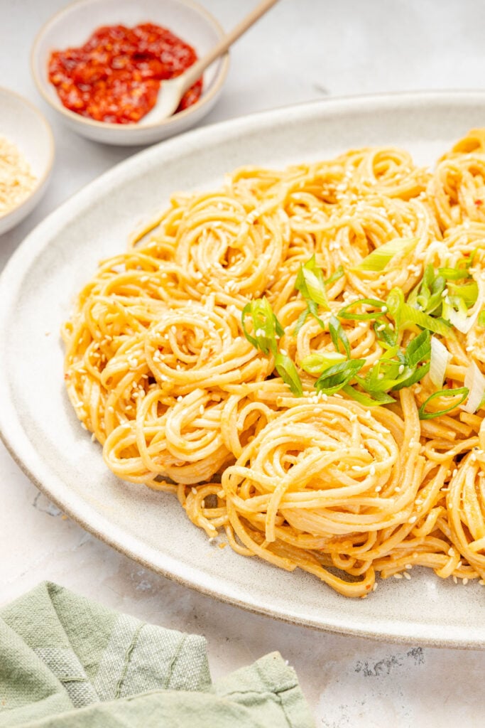 Sesame Noodles on a plate with scallions on top.