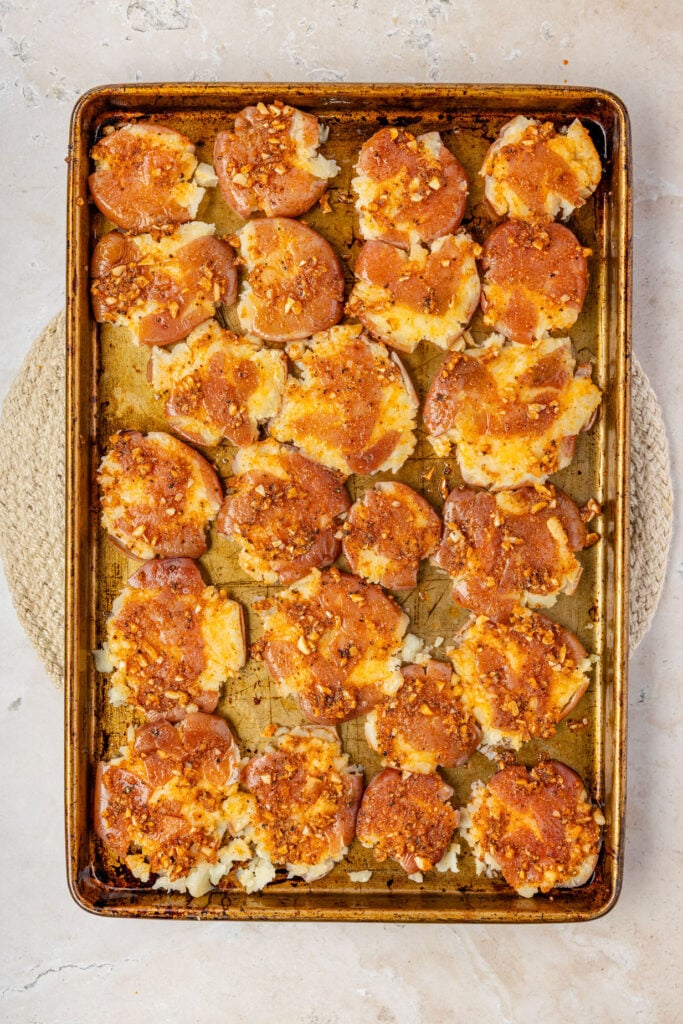 Brushed garlic butter on top of the smashed potatoes on a sheet pan.