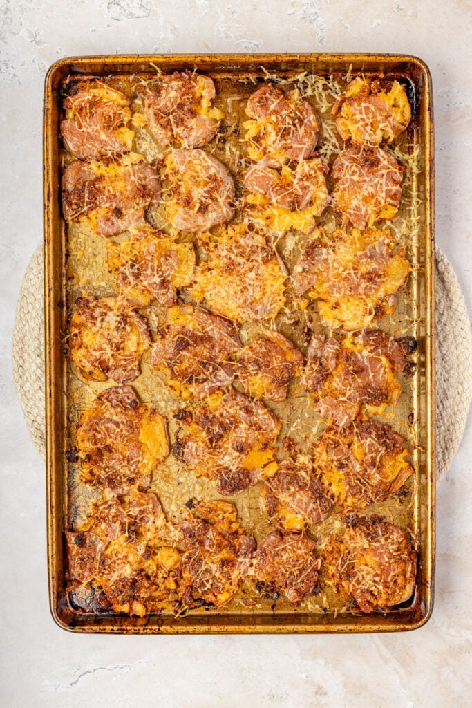 Mashed potatoes on a sheet pan with Parmesan cheese.