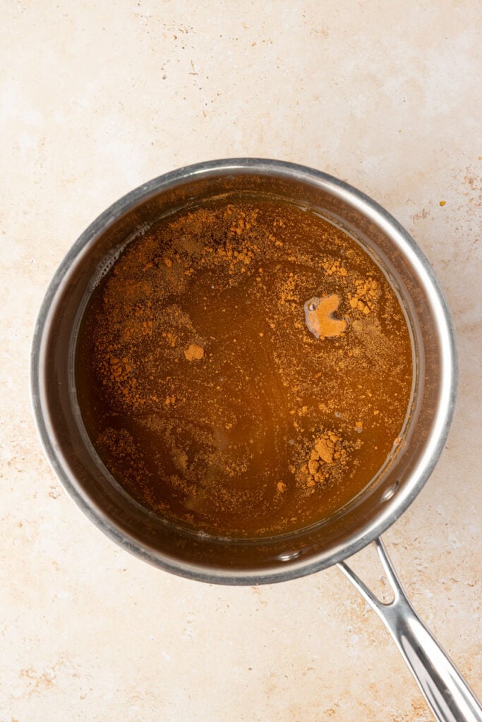 Apple cider, spices, vanilla, brown sugar in a pot.