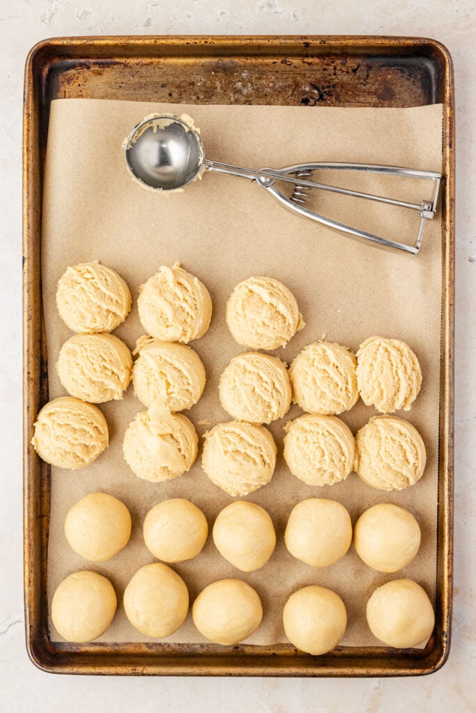 Raw cookie dough, scooped out onto a sheet pan