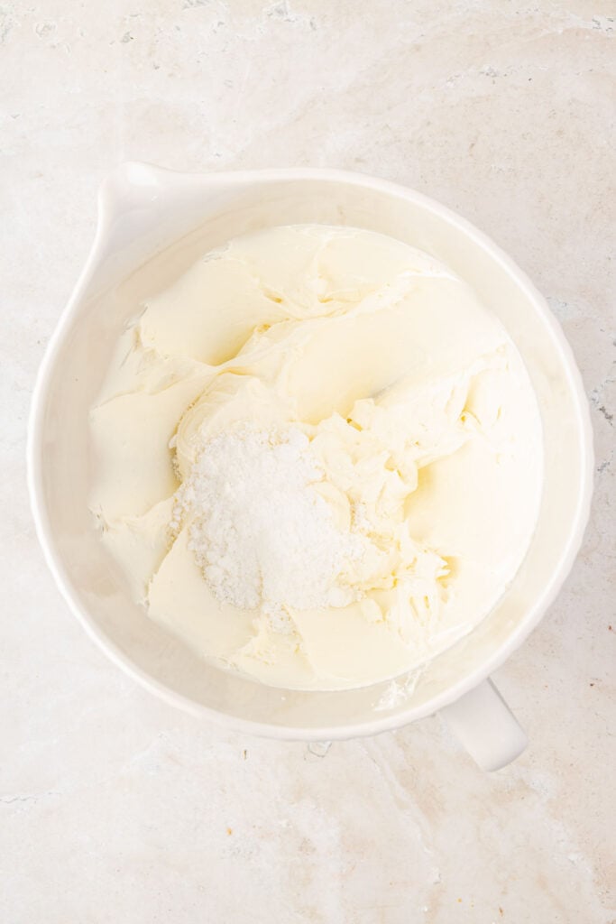 Whipped up ricotta cheese, and cream cheese with powdered sugar in a mixing bowl
