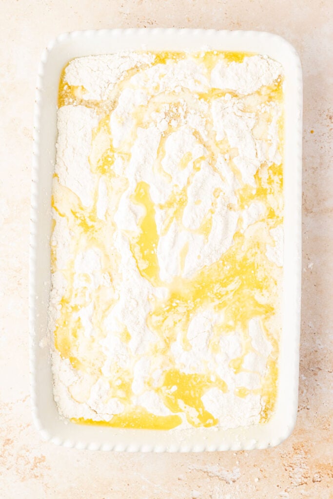 Butter drizzled on top of cake mix in a cake pan