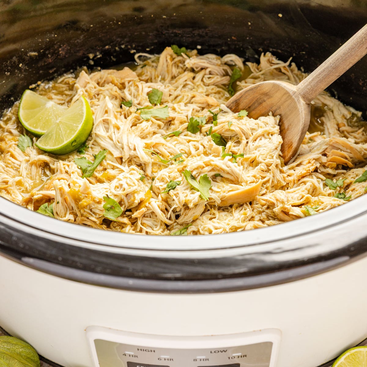 Slow Cooker Salsa Verde Chicken in slow cooker with spoon.