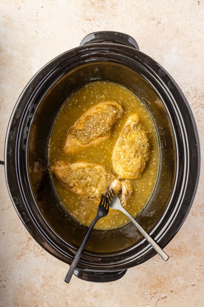 two forks shredding Slow Cooker Salsa Verde Chicken.