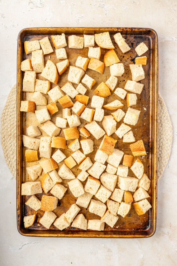 Cubed bread on a sheet pan ready to go into the oven to dry out.