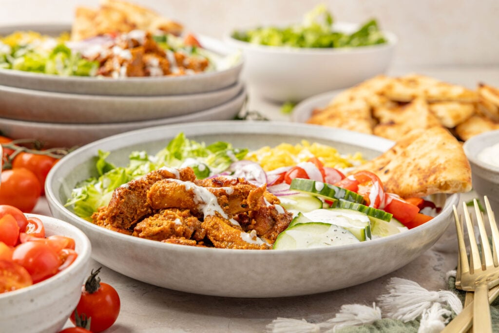 Chicken Shawarma Bowl with cherry tomatoes and lettuce around it.