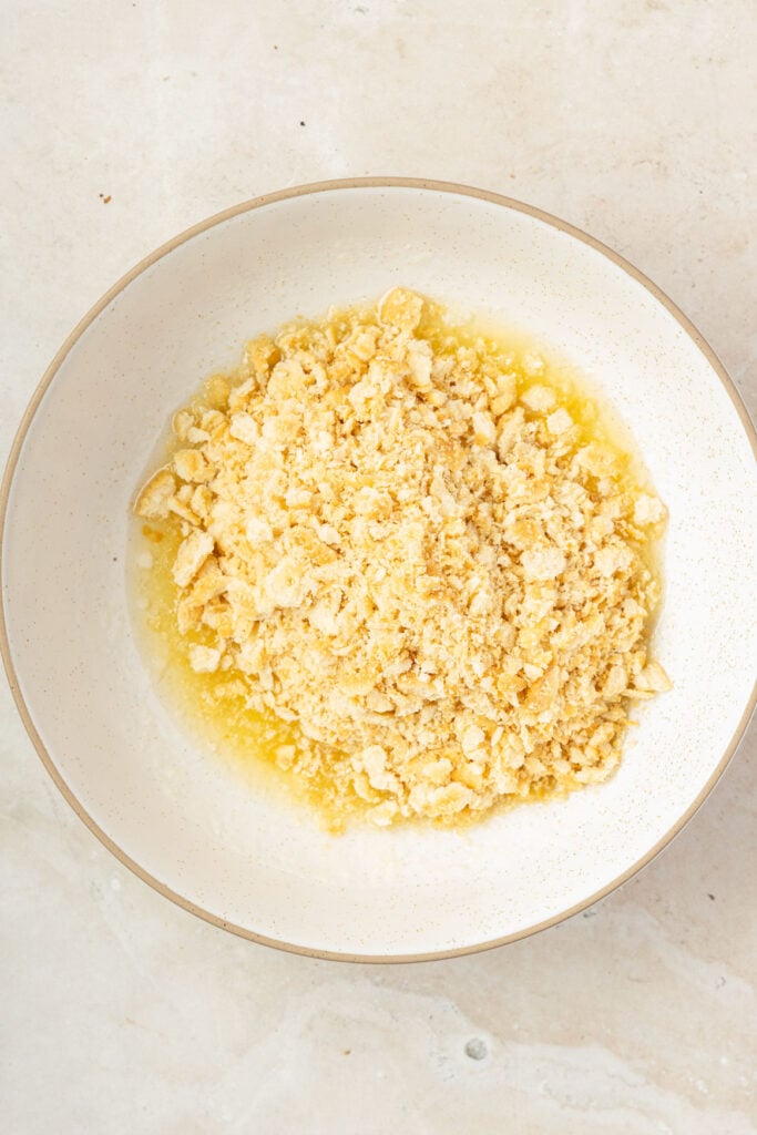 Butter and crushed Ritz crackers in a mixing bowl