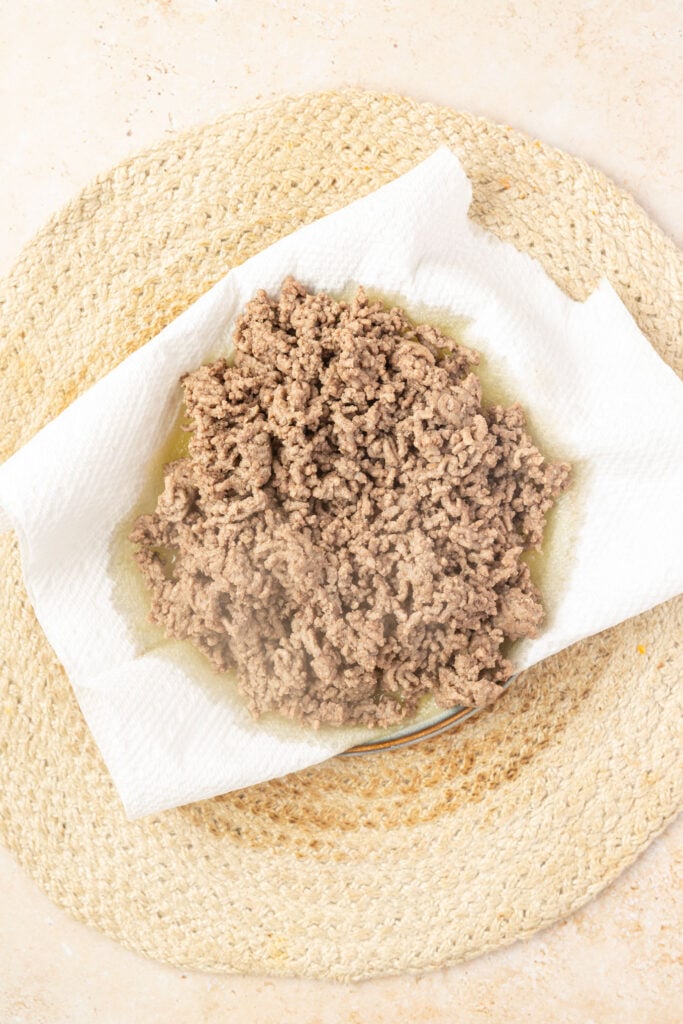 Ground beef on a plate with paper towels to drain off excess grease.