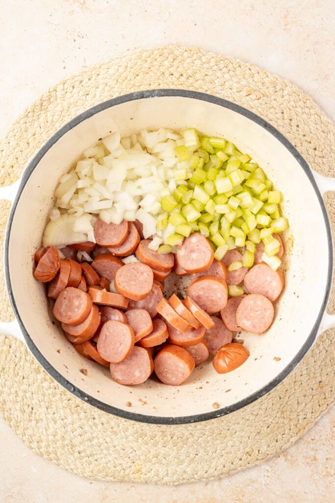Raw sausage, onions and celery in a Dutch oven.