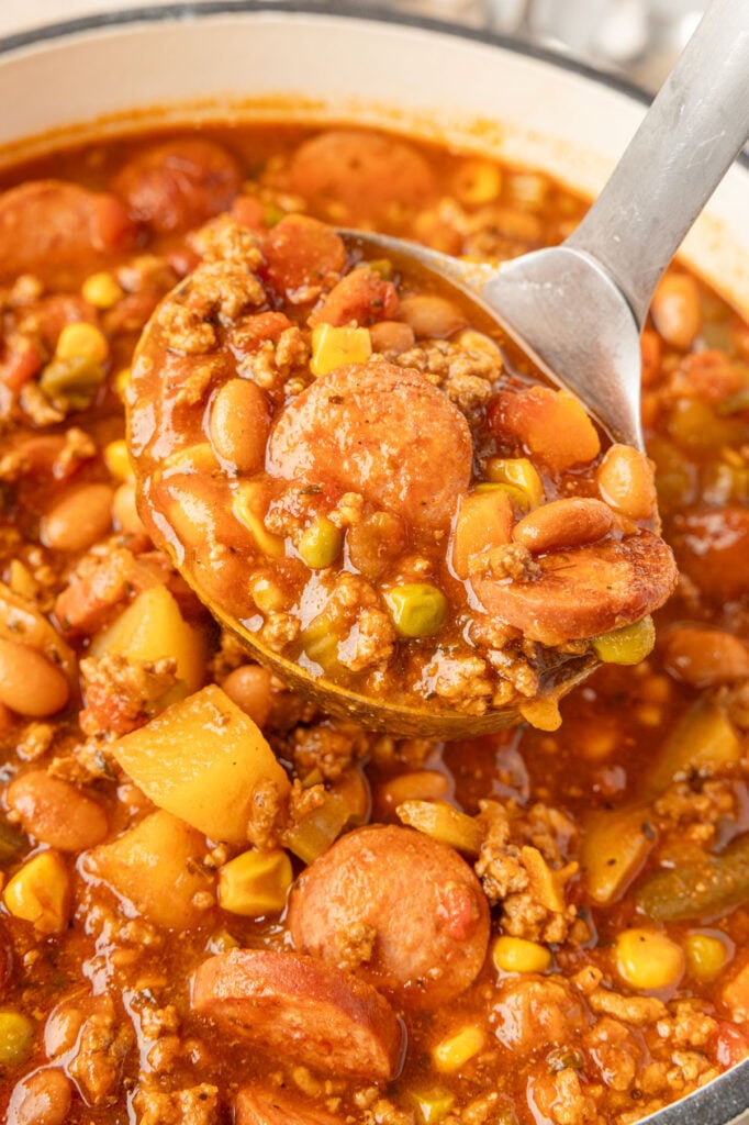 Cowboy Stew in a pot with a little scooping up some.