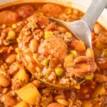 Cowboy Stew in a pot with a little scooping up some.