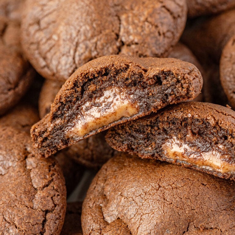 Close-up image of a cut in half Rolo Cookie piled on top of Rolo Cookies.