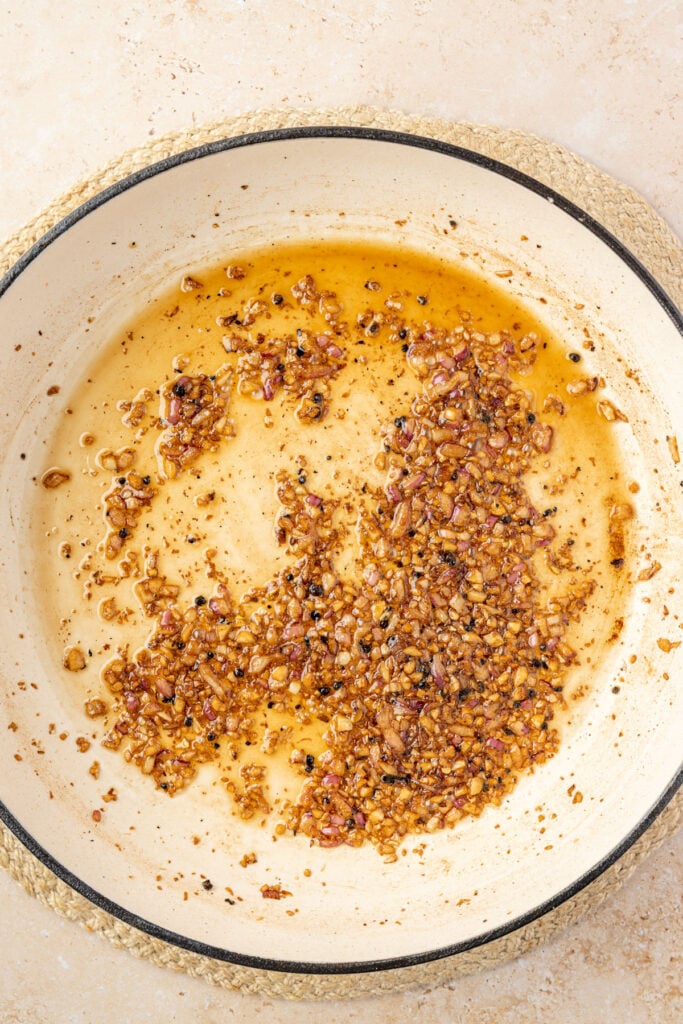 shallots, garlic and a wine in a skillet