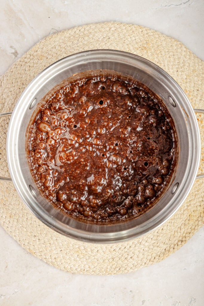 Boiling chocolate, no bake cookie mixture in a pot.