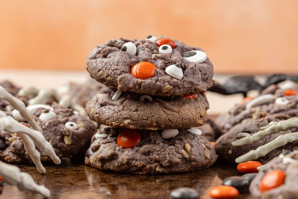 Halloween Monster Cookies on a medal background with skeleton hands, and Halloween M&M