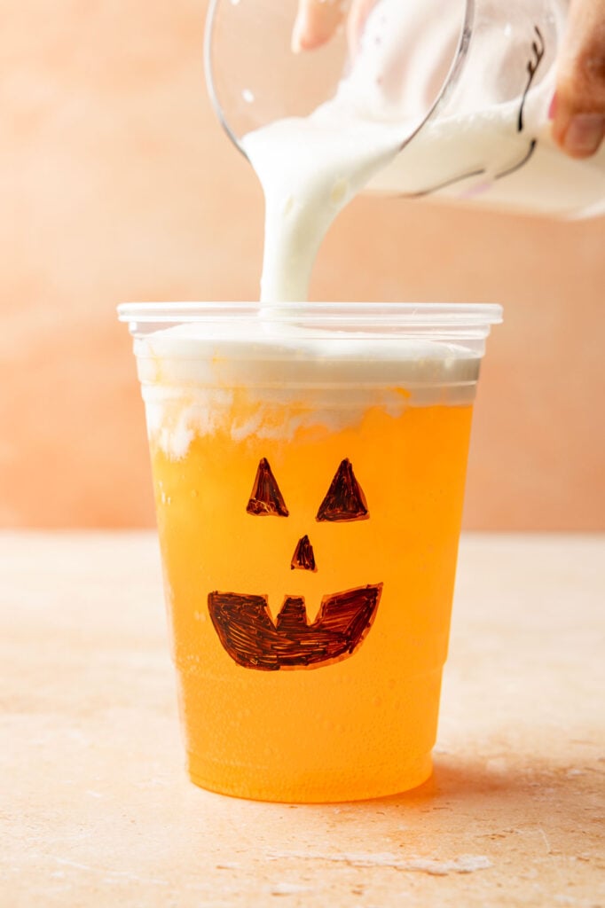 Cold foam being poured on Jack-O’-Lantern Dirty Soda.