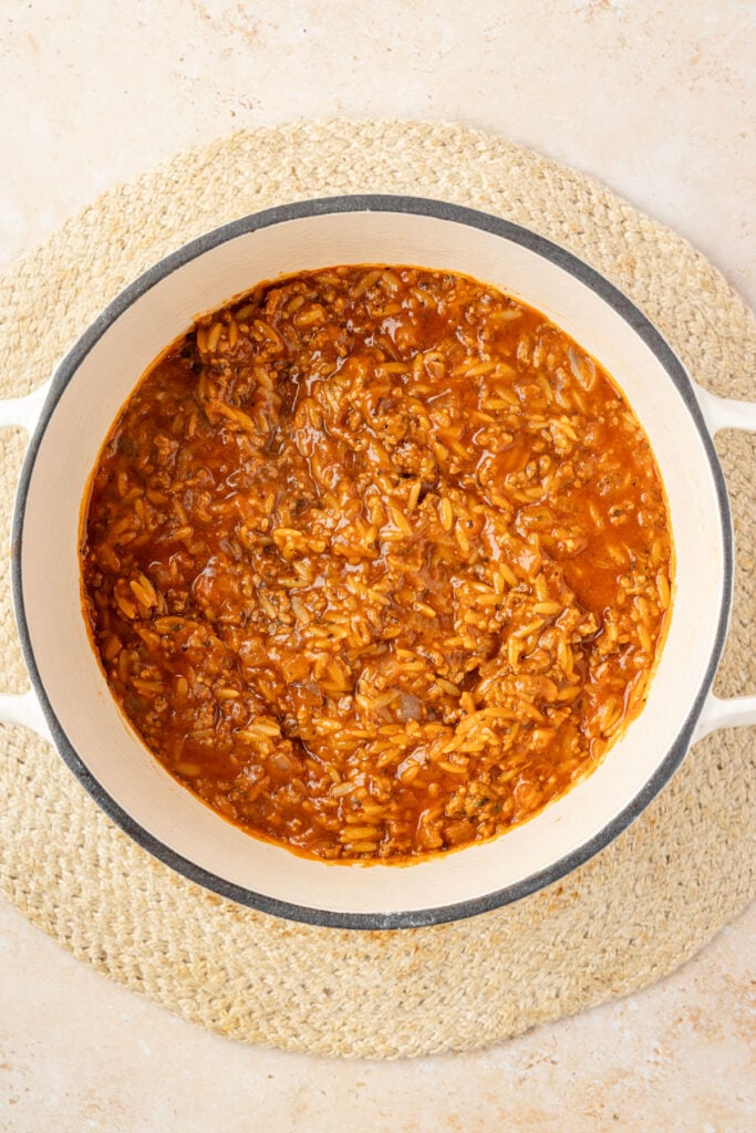 Cooked orzo mixture in a white Dutch oven.