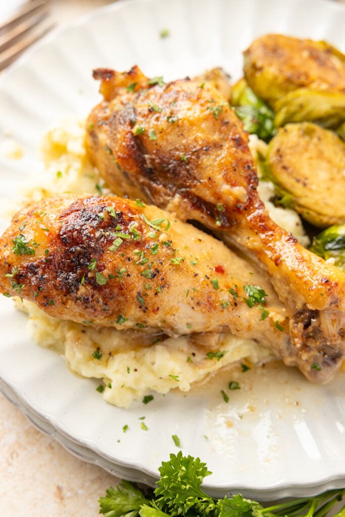 Close up of slow cooker drumsticks on a plate.