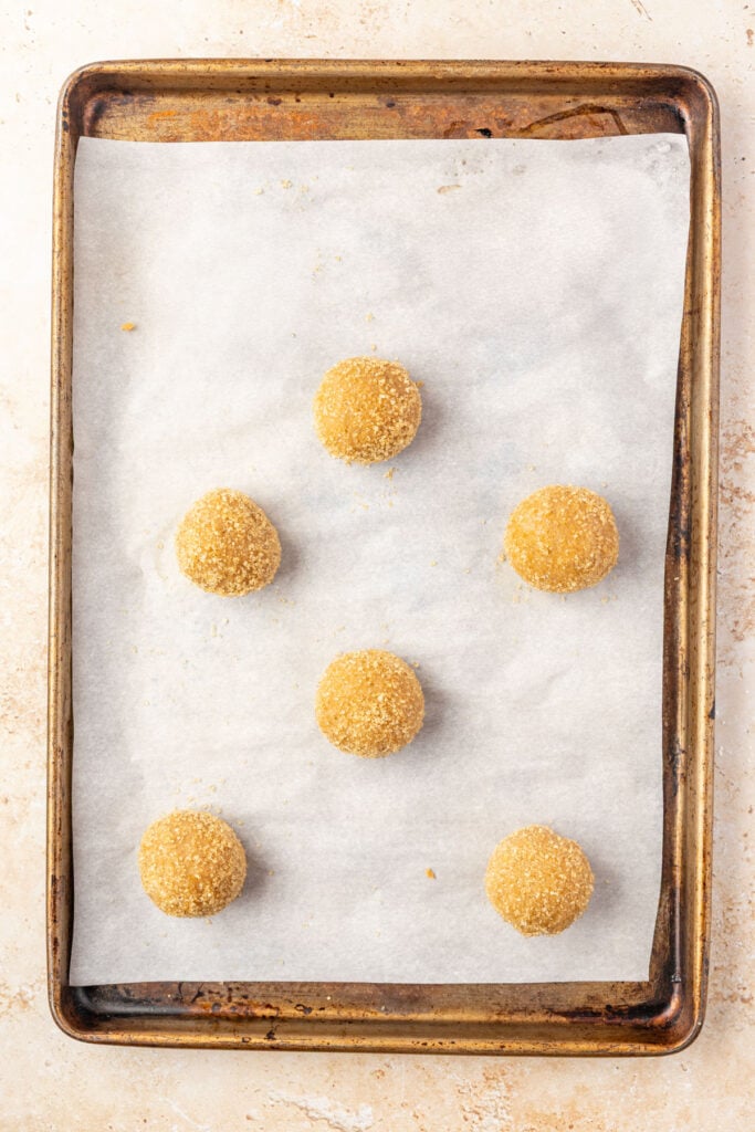 raw cookie balls on a sheet pan.