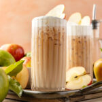 Apple Chai Latte on a tray with apples and leaves around it